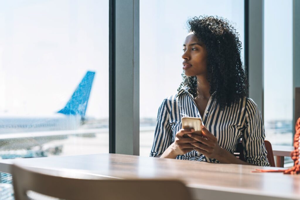 Frau mit Handy am Flughafen